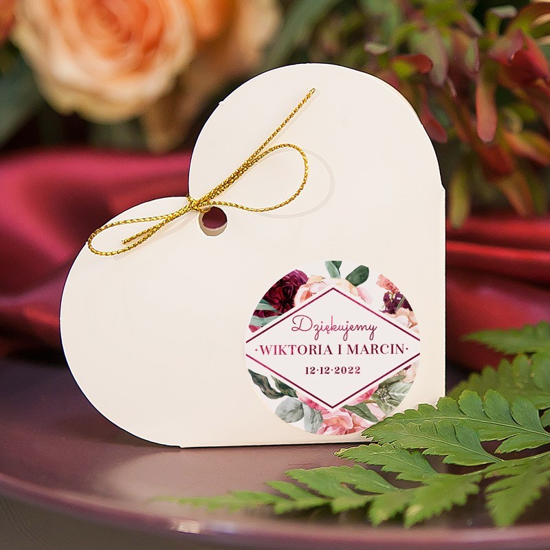 Białe pudełeczka serce posiadają ozdobne etykiety. Idealny upominek dla gości weselnych.
