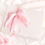 Różowa satynowa kokardka na wieczku pudełka - dekoracja