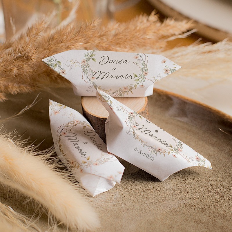 Cukierki krówki w ozdobnych papierkach na ślubne podziękowanie dla gości.