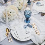 Stół weselny udekorowany w stylu klasycznym, z białymi obrusami i talerzami