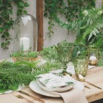 Dekoracje weselne w stylu Botanicznym, na długim drewnianym stole, otoczone zieloną roślinnością oraz dodatkami z kolekcji Bot