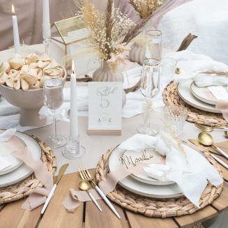 Dekoracja stołu weselnego z drewnianymi dodatkami, białą zastawą i nowoczesnymi sztućcami