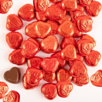 Czekoladki w kształcie serca w czerwonych papierkach.