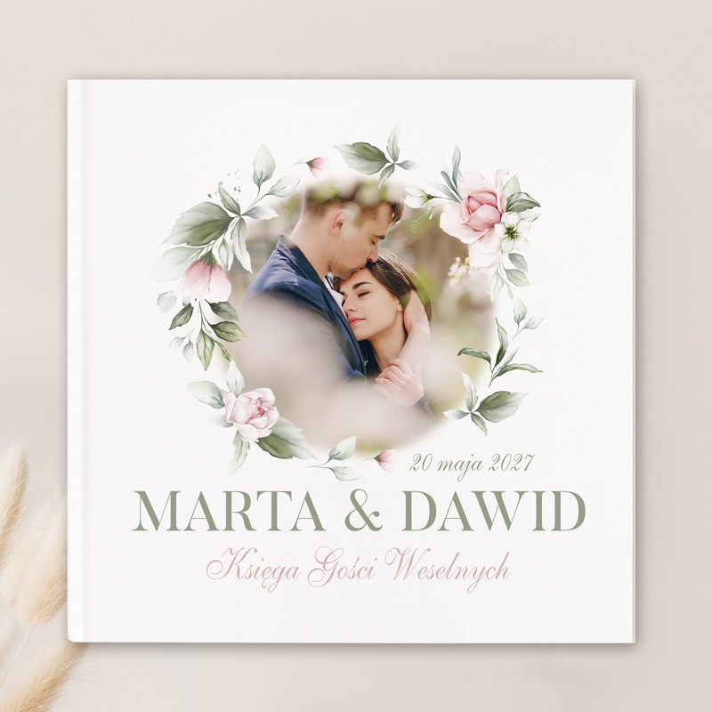 Księga gości ze zdjęciem Pary Młodej na okładce z kwiatowym wiankiem.