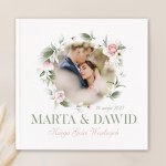 Księga gości ze zdjęciem Pary Młodej na okładce z kwiatowym wiankiem.