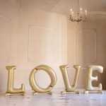 duży napis love w formie balonów w kolorze złotym