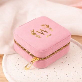 Różowa szkatułka ze złotym inicjałem.