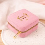 Różowa szkatułka ze złotym inicjałem.