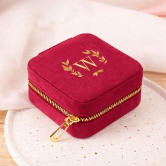 Bordowa szkatułka ze złotym inicjałem.