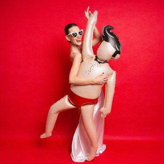 Kobieta trzyma zabawny balon foliowy w kształcie mężczyzny podczas wieczoru panieńskiego