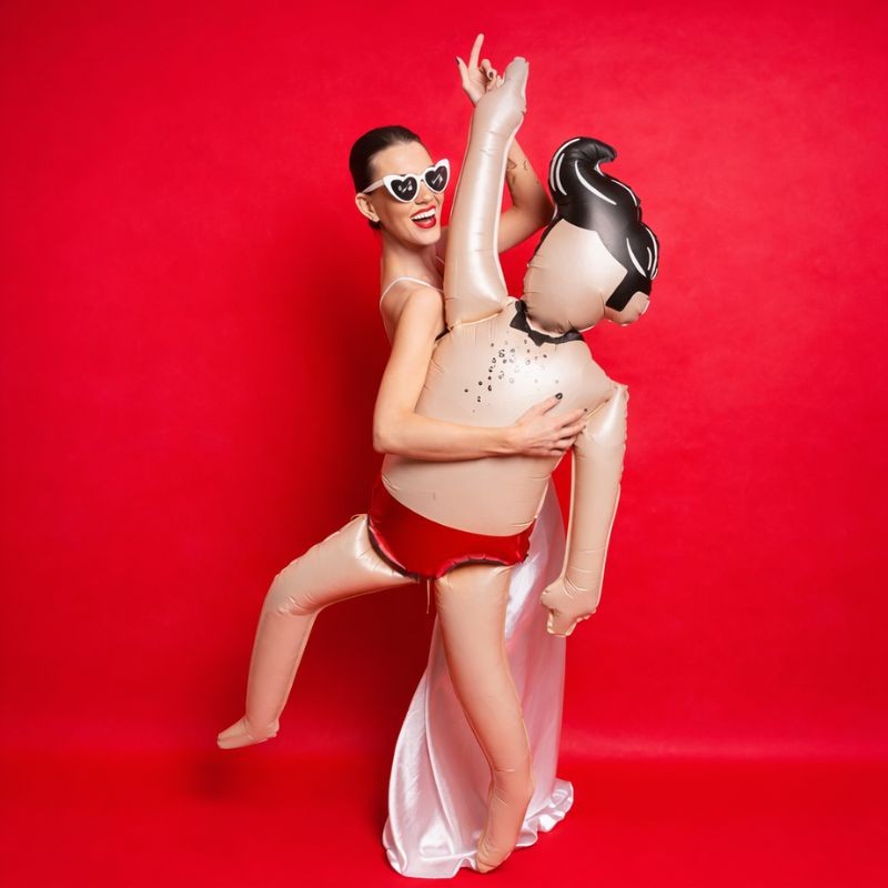 Kobieta trzyma zabawny balon foliowy w kształcie mężczyzny podczas wieczoru panieńskiego