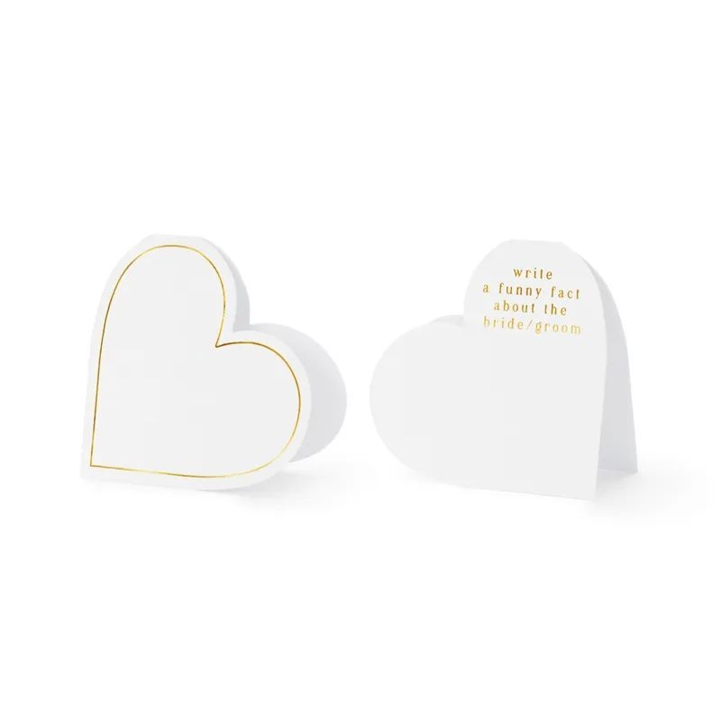 Białe wizytówki serca ze złotym zdobieniem. Dekoracja stołu ślubnego.