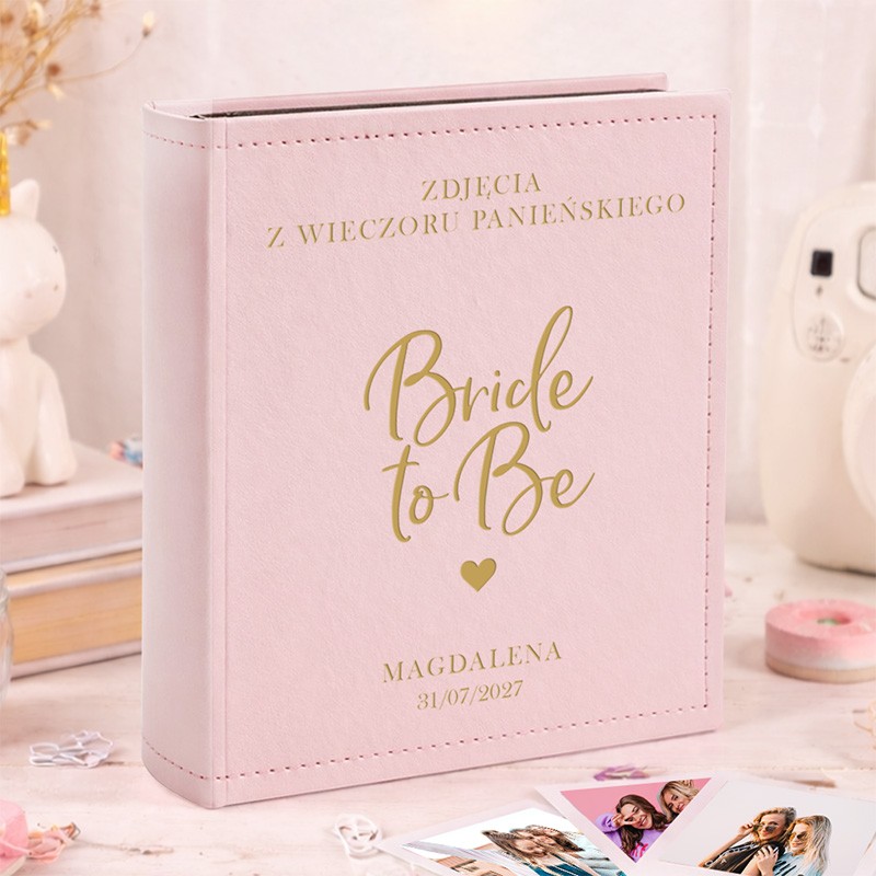 Personalizowany różowy album na zdjęcia Instax z napisem "Bride to Be", imieniem i datą wieczoru panieńskiego.