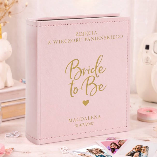 Personalizowany różowy album na zdjęcia Instax z napisem "Bride to Be", imieniem i datą wieczoru panieńskiego.
