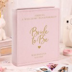 Personalizowany różowy album na zdjęcia Instax z napisem "Bride to Be", imieniem i datą wieczoru panieńskiego.