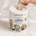 Biała ceramiczna skarbonka z imionami pary, napisem na podróż dookoła świata oraz grafiką globusa, walizki, paszportu i mapy.