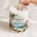 Biała ceramiczna skarbonka na podróż na Malediwy z imionami pary, palmami, turkusowym morzem i domkami na wodzie.