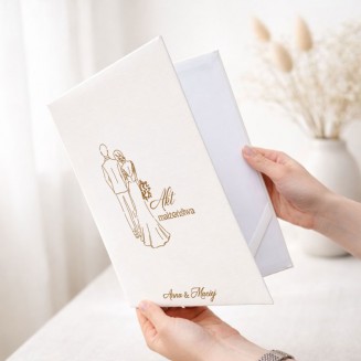 Personalizowana teczka na akt małżeństwa ma elegancką białą okładkę ze złotą ilustracją Pary Młodej i imionami