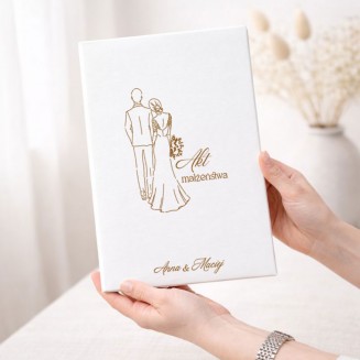 Personalizowana teczka na akt małżeństwa ma elegancką białą okładkę ze złotą ilustracją Pary Młodej i imionami