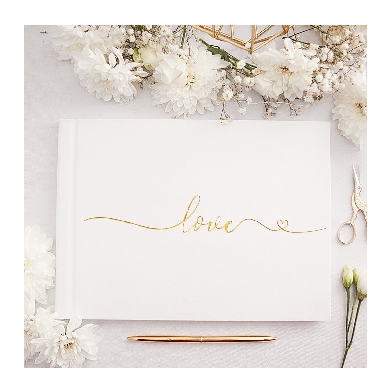Złoty, metaliczny napis ""love"" na białej okładce księgi gości.