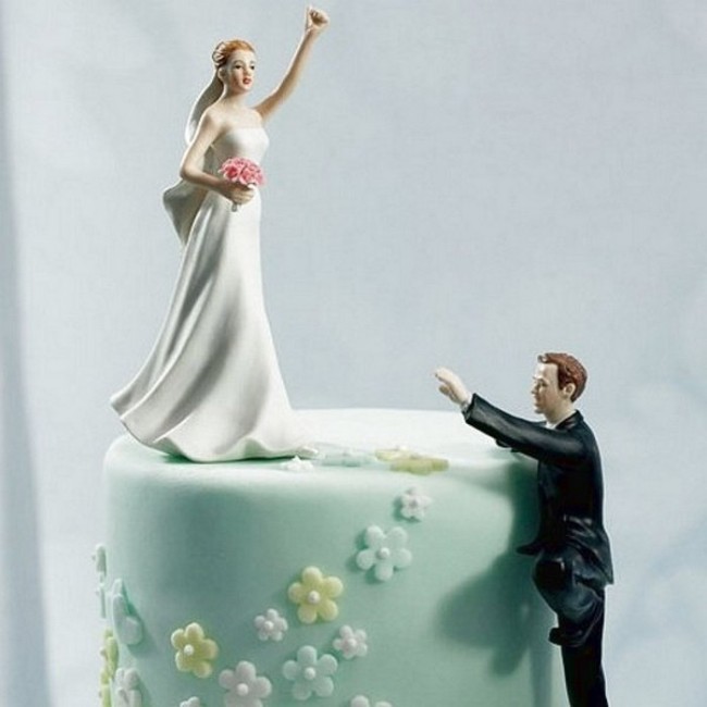 Figurka na tort z dwóch postaci panna młoda na górze, a pan młody wspina się do niej