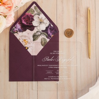 Zaproszenie ślubne akrylowe z tekstem zapisanym białą czcionką. Purpurowa koperta z wklejką w kwiaty.