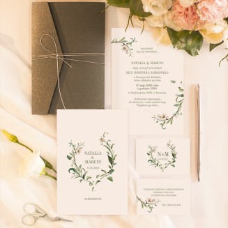 Zaproszenia ślubne z ciemną kopertą przewiązaną srebrnym sznureczkiem. Dwustronne zaproszenie z motywem gałązek z liliami.