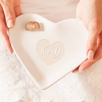 Talerzyk pod obrączki. Ma kształt białego serca i wykonany jest z ceramiki. Wzór wygrawerowanego serca z inicjałami.