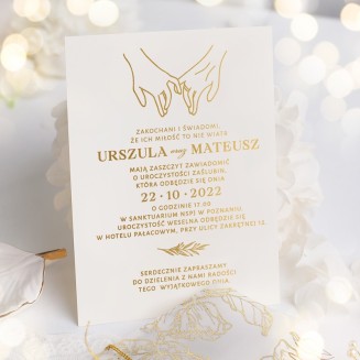 Zaproszenie ślubne ze złoconym nadrukiem w zestawie z ozdobną kopertą przewiązaną złotym sznurkiem.